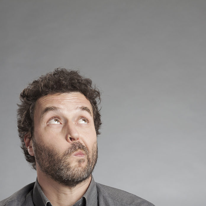Man in grey shirt looking up